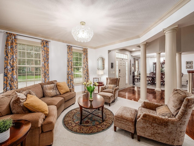 6676 Ballantrae Pl, Dublin, OH 43016 - living room featuring ornate columns, crown molding, healthy amount of natural light, wood finished floors, and a chandelier