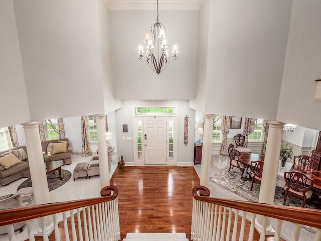6676 Ballantrae Pl, Dublin, OH 43016 - entrance foyer featuring a high ceiling, a chandelier, wood finished floors, decorative columns, and crown molding