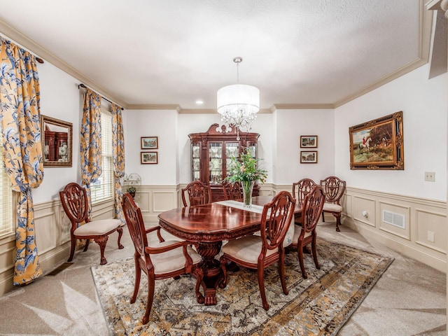 6676 Ballantrae Pl, Dublin, OH 43016 - carpeted dining room with a decorative wall, ornamental molding, wainscoting, and a chandelier
