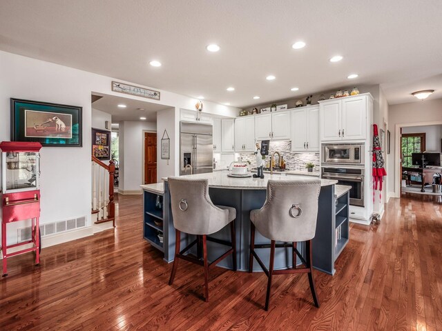 6676 Ballantrae Pl, Dublin, OH 43016 - kitchen with built in appliances, white cabinetry, recessed lighting, dark wood-style flooring, and backsplash