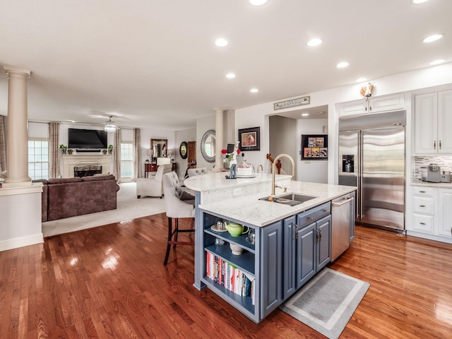 6676 Ballantrae Pl, Dublin, OH 43016 - kitchen with appliances with stainless steel finishes, decorative columns, white cabinetry, open shelves, and open floor plan