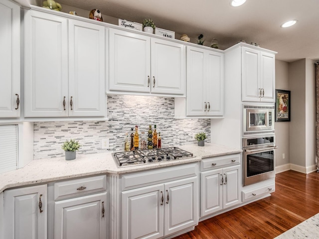 6676 Ballantrae Pl, Dublin, OH 43016 - kitchen featuring appliances with stainless steel finishes, white cabinets, dark wood-type flooring, decorative backsplash, and recessed lighting