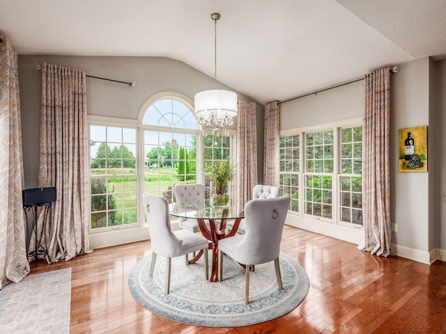 6676 Ballantrae Pl, Dublin, OH 43016 - dining area with vaulted ceiling, a chandelier, and wood finished floors
