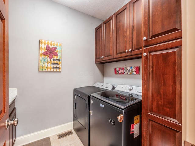 6676 Ballantrae Pl, Dublin, OH 43016 - washroom featuring independent washer and dryer, cabinet space, tile patterned floors, and a textured ceiling