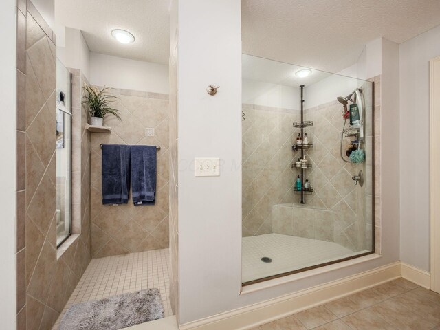6676 Ballantrae Pl, Dublin, OH 43016 - full bathroom with tile patterned flooring, a tile shower, and a textured ceiling