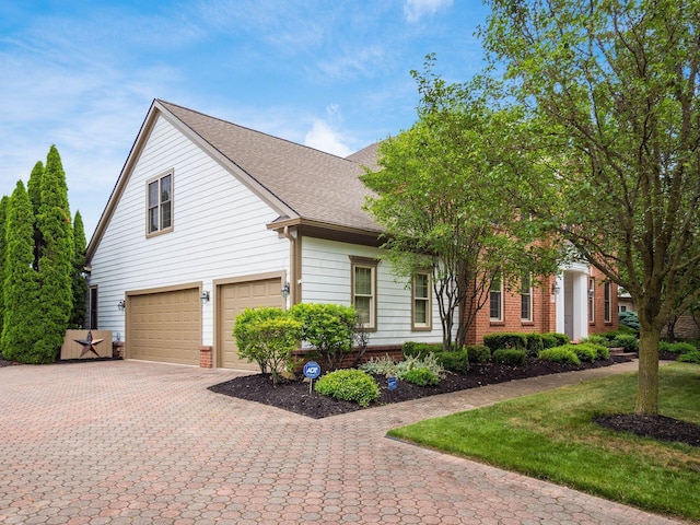 6676 Ballantrae Pl, Dublin, OH 43016 - view of front of property featuring a garage, decorative driveway, brick siding, a shingled roof, and a front lawn