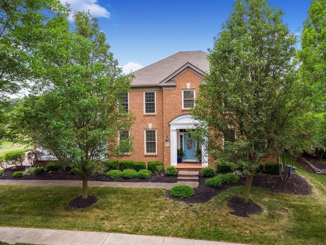 6676 Ballantrae Pl, Dublin, OH 43016 - colonial inspired home featuring a front yard, brick siding, and roof with shingles