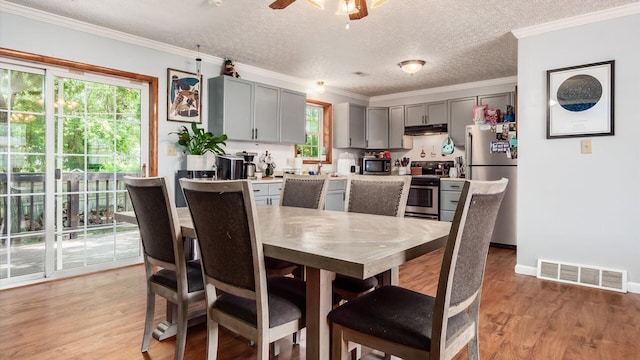 13376 Maple Rd NE, Thornville, OH 43076 - dining area with light wood-style flooring, ceiling fan, a textured ceiling, and ornamental molding