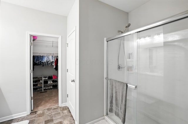 172 Rosewood Loop SE, Commercial Point, OH 43116 - bathroom with a shower stall, stone finish flooring, and a walk in closet