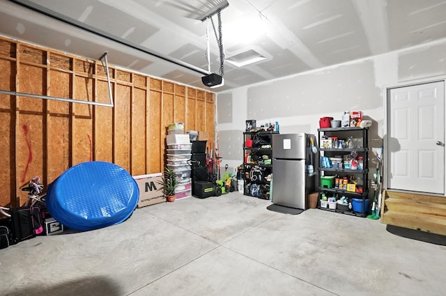 172 Rosewood Loop SE, Commercial Point, OH 43116 - garage featuring freestanding refrigerator and a garage door opener
