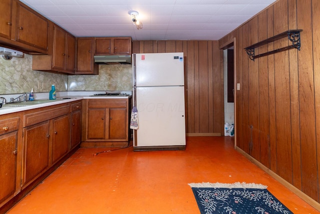 5375 Fullerton Dr, Columbus, OH 43232 - kitchen with freestanding refrigerator, under cabinet range hood, brown cabinets, backsplash, and light countertops