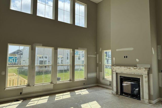 6938 Stillhouse Ln, Dublin, OH 43016 - unfurnished living room featuring plenty of natural light, a towering ceiling, and a premium fireplace