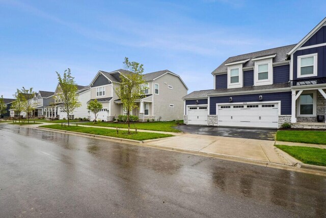 6938 Stillhouse Ln, Dublin, OH 43016 - townhome / multi-family property with a residential view, concrete driveway, board and batten siding, and stone siding