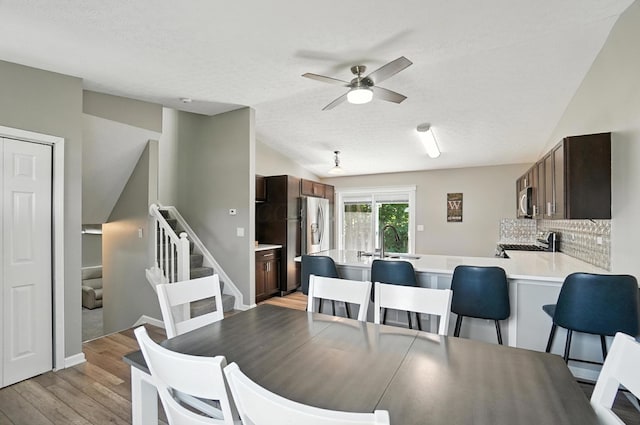 6803 Alex Dr, Canal Winchester, OH 43110 - dining space with lofted ceiling, stairway, ceiling fan, light wood finished floors, and a textured ceiling