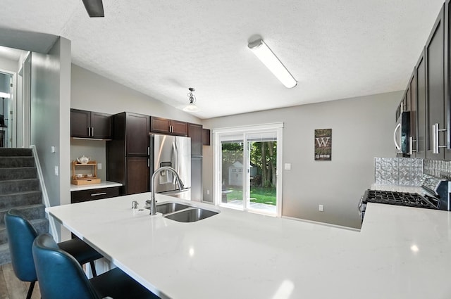 6803 Alex Dr, Canal Winchester, OH 43110 - kitchen featuring appliances with stainless steel finishes, light countertops, a peninsula, a breakfast bar, and a textured ceiling