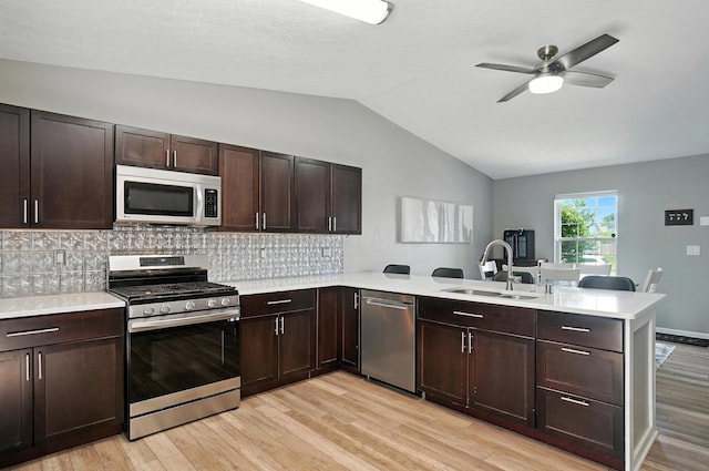 6803 Alex Dr, Canal Winchester, OH 43110 - kitchen featuring stainless steel appliances, a peninsula, lofted ceiling, light countertops, and light wood finished floors