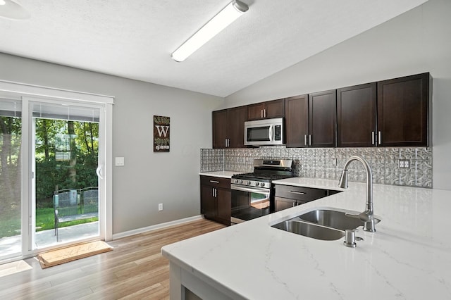 6803 Alex Dr, Canal Winchester, OH 43110 - kitchen with stainless steel appliances, decorative backsplash, vaulted ceiling, light stone counters, and light wood-type flooring