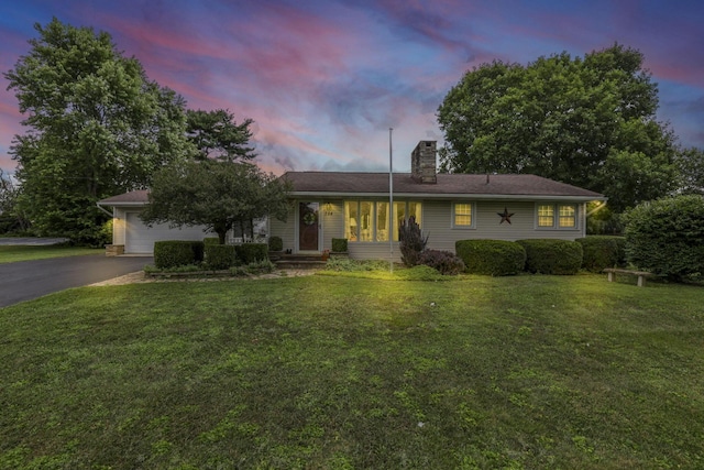 784 Colonial Dr, Heath, OH 43056 - ranch-style house featuring asphalt driveway, a chimney, a garage, and a lawn