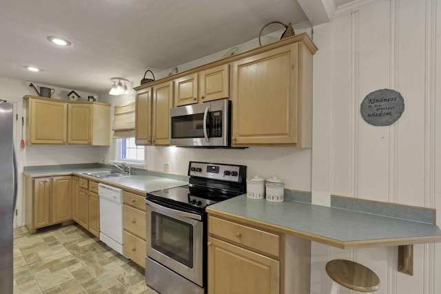 784 Colonial Dr, Heath, OH 43056 - kitchen featuring appliances with stainless steel finishes, light brown cabinets, a breakfast bar, stone finish flooring, and recessed lighting
