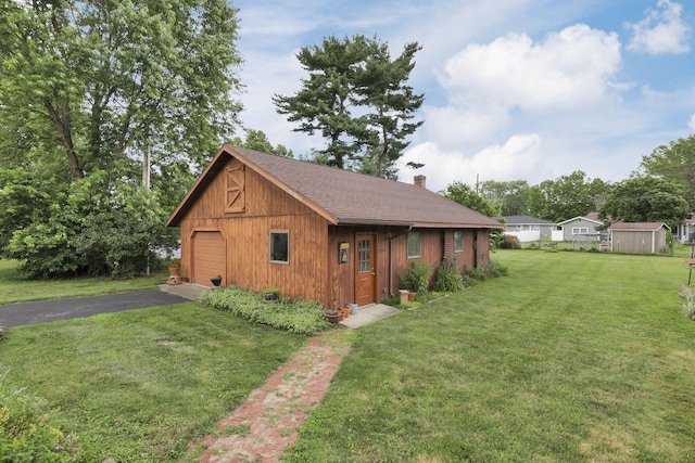 784 Colonial Dr, Heath, OH 43056 - view of front of property with a chimney, driveway, a front lawn, an outbuilding, and a garage