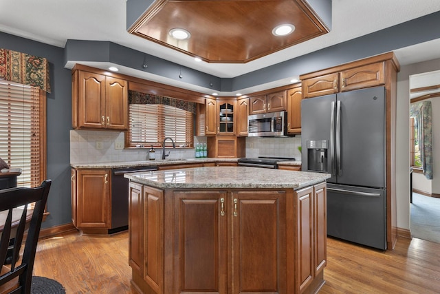 5232 Lola Way, Columbus, OH 43235 - kitchen featuring stainless steel appliances, light wood finished floors, a kitchen island, tasteful backsplash, and light stone countertops