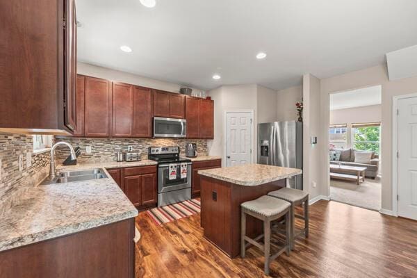 3810 Winding Path Dr, Canal Winchester, OH 43110 - kitchen featuring appliances with stainless steel finishes, a breakfast bar, dark wood finished floors, a kitchen island, and recessed lighting