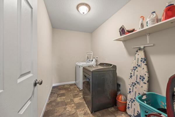 3810 Winding Path Dr, Canal Winchester, OH 43110 - laundry room with washer and dryer and stone finish floors