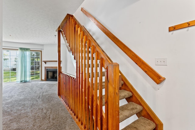 5692 Palos Ln Unit 168D, Hilliard, OH 43026 - stairs featuring carpet, a fireplace with flush hearth, and a textured ceiling
