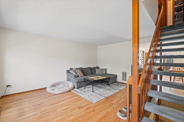 907 Soramill Ln Unit 8E, Columbus, OH 43085 - living area with stairs, wood finished floors, and a textured ceiling