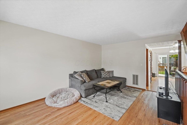 907 Soramill Ln Unit 8E, Columbus, OH 43085 - living area with wood finished floors and a textured ceiling