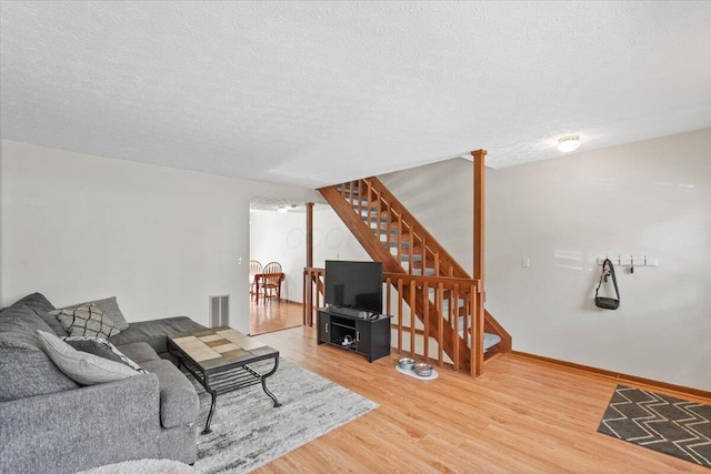 907 Soramill Ln Unit 8E, Columbus, OH 43085 - living room featuring stairway, wood finished floors, and a textured ceiling