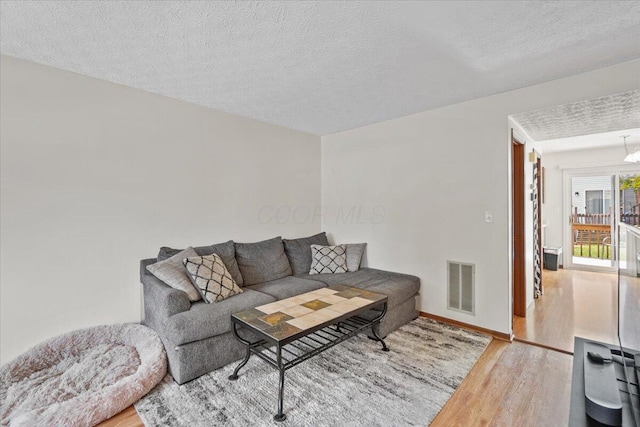 907 Soramill Ln Unit 8E, Columbus, OH 43085 - living room featuring wood finished floors and a textured ceiling