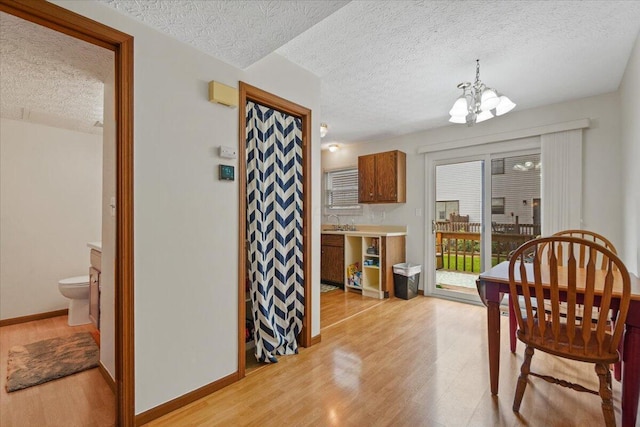 907 Soramill Ln Unit 8E, Columbus, OH 43085 - dining space with a textured ceiling, light wood-style flooring, and a chandelier