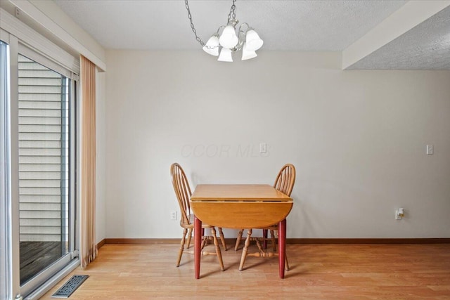 907 Soramill Ln Unit 8E, Columbus, OH 43085 - dining room featuring a chandelier, light wood-style flooring, and a textured ceiling