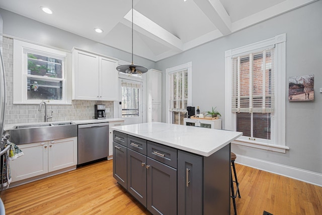 133 E Sycamore St, Columbus, OH 43206 - kitchen with stainless steel dishwasher, white cabinets, decorative light fixtures, light wood-style floors, and decorative backsplash