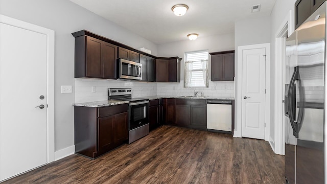1968 Highbridge St, Newark, OH 43055 - kitchen featuring appliances with stainless steel finishes, backsplash, dark brown cabinetry, and dark wood-style flooring