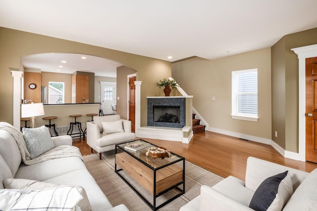 1293 Avondale Ave, Columbus, OH 43212 - living area featuring arched walkways, light wood finished floors, a fireplace, and recessed lighting