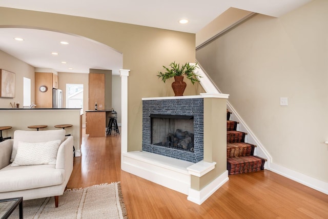 1293 Avondale Ave, Columbus, OH 43212 - living area with wood finished floors, a tile fireplace, arched walkways, stairs, and recessed lighting