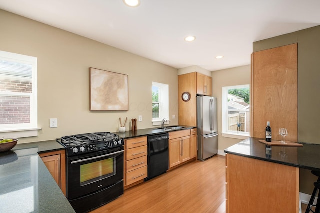 1293 Avondale Ave, Columbus, OH 43212 - kitchen featuring black appliances, light wood-type flooring, recessed lighting, a kitchen breakfast bar, and dark stone countertops