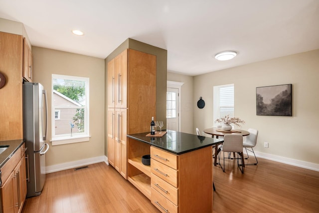 1293 Avondale Ave, Columbus, OH 43212 - kitchen with freestanding refrigerator, light wood-type flooring, dark countertops, plenty of natural light, and recessed lighting