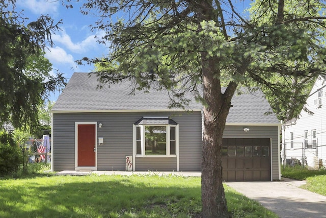 977 Sells Ave, Columbus, OH 43212 - view of front of home featuring a shingled roof, a front yard, driveway, and an attached garage