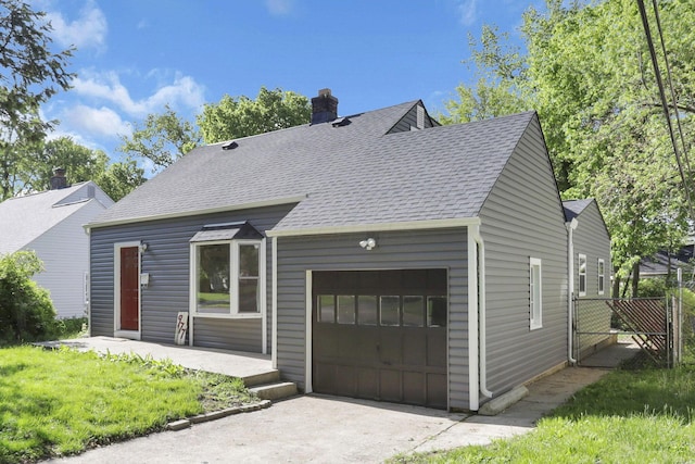 977 Sells Ave, Columbus, OH 43212 - cape cod home featuring a garage, a chimney, a shingled roof, and driveway