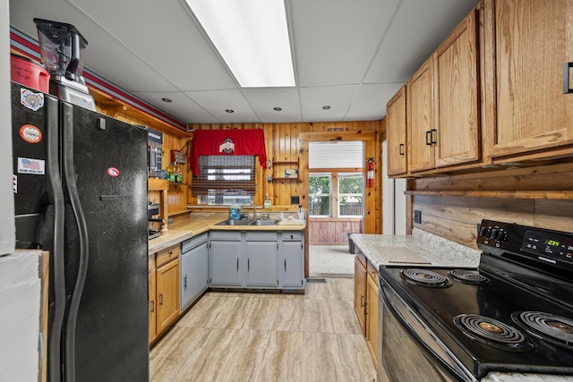716 Uncapher Ave, Marion, OH 43302 - kitchen with black appliances, light countertops, wood walls, and a paneled ceiling