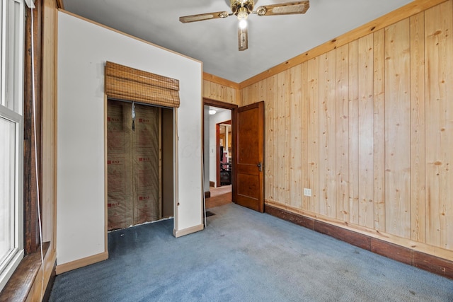 716 Uncapher Ave, Marion, OH 43302 - unfurnished bedroom featuring carpet flooring, wooden walls, a ceiling fan, and a closet