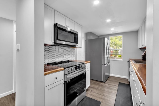 1030 Galliton Ct Unit B, Columbus, OH 43220 - kitchen with stainless steel appliances, butcher block counters, white cabinetry, tasteful backsplash, and light wood-style floors