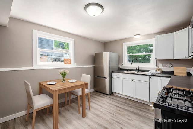 226 N Southampton Ave, Columbus, OH 43204 - kitchen with appliances with stainless steel finishes, dark countertops, white cabinets, and light wood-type flooring
