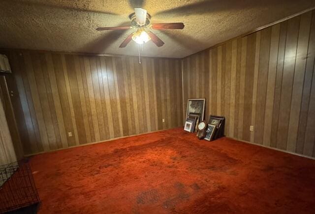278 Cullman Rd, Columbus, OH 43207 - unfurnished room featuring ceiling fan, a textured ceiling, wood walls, and carpet