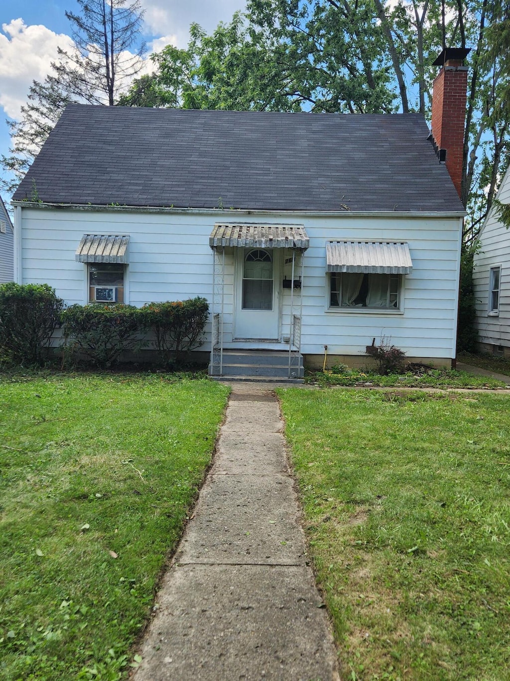 769 Elizabeth Ave, Columbus, OH 43227 - view of front of home featuring a front yard, a shingled roof, a chimney, and entry steps