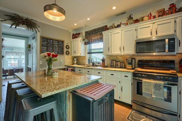 1715 Carroll Southern Rd NW, Carroll, OH 43112 - kitchen featuring stainless steel appliances, white cabinets, backsplash, ornamental molding, and light stone countertops