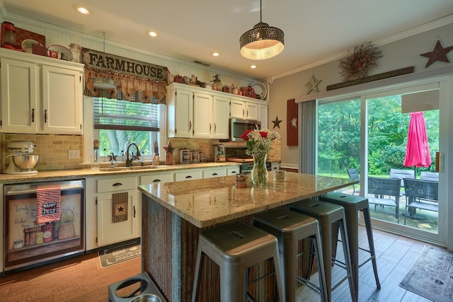 1715 Carroll Southern Rd NW, Carroll, OH 43112 - kitchen featuring stainless steel microwave, ornamental molding, white cabinetry, decorative backsplash, and a breakfast bar